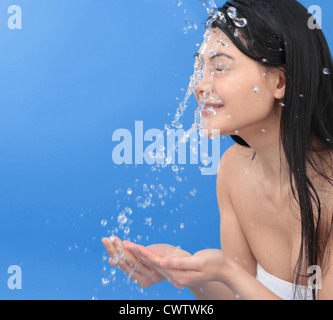 Jeune femme aux cheveux noirs et aux éclaboussures d'eau Banque D'Images