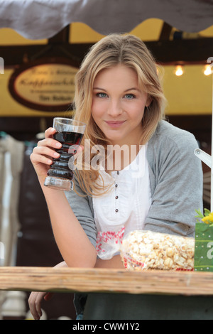 Femme souriante avec une boisson sur une fête foraine Banque D'Images