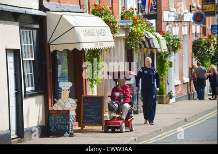 Dame âgée à l'aide de mobility scooter dans Bromyard Herefordshire Angleterre UK Banque D'Images