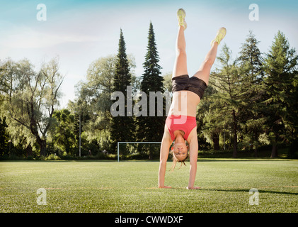 Woman doing cartwheel dans park Banque D'Images