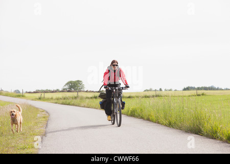 Man riding bicycle with dog Banque D'Images