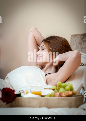 Femme un réveil au petit déjeuner au lit Banque D'Images