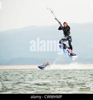 Sports extrêmes : un homme kite surf sur l'eau sur un après-midi d'août, plage de las Ynys Dyfi, estuaire, West Wales UK Banque D'Images