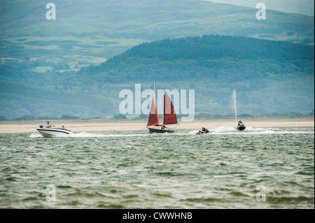 Un voilier, jet ski et bateau de moteur sur un après-midi d'août, Ynys las, estuaire Dyfi, West Wales UK Banque D'Images