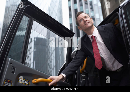 Businessman climbing out of taxi cab Banque D'Images