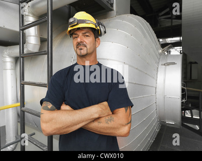 Worker in hard hat standing in factory Banque D'Images