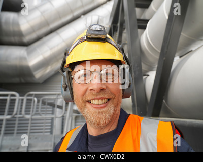 Worker wearing hard hat en usine Banque D'Images