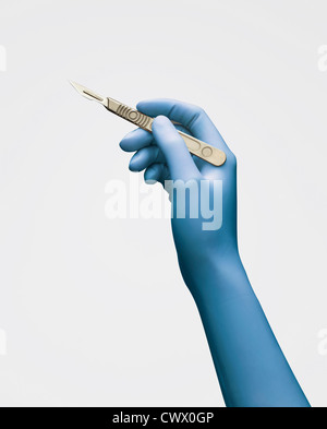 Close up of gloved hand holding scalpel Banque D'Images