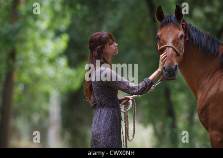 Woman walking horse in forest Banque D'Images