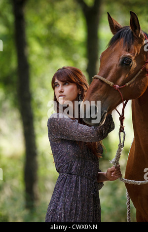 Woman walking horse in forest Banque D'Images