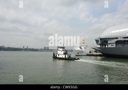 Un remorqueur tire dans la rivière Hudson avec un National Oceanic and Atmospheric Administration l'expédition dans l'arrière-plan. Banque D'Images