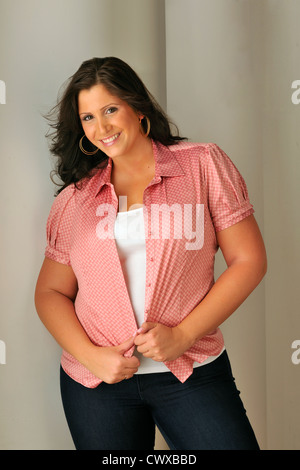 De taille plus attrayant model wearing red blouse en studio. Banque D'Images