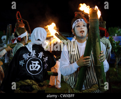 Pause artistes du Festival à la lumière de leurs torches bambou pendant l'événement Eisa Heshikiya à Okinawa, au Japon. Banque D'Images