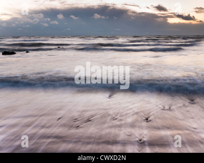 Coucher de soleil sur Compton Bay sur l'île de Wight, avec des nuages menaçants. Banque D'Images