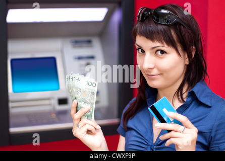 Belle femme en utilisant la carte de crédit, elle est le retrait d'argent d'un guichet automatique. Banque D'Images
