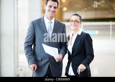 Happy young businessman and businesswoman at airport Banque D'Images