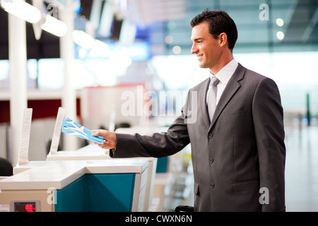 Handsome businessman handing over air billet au comptoir de compagnie aérienne Banque D'Images