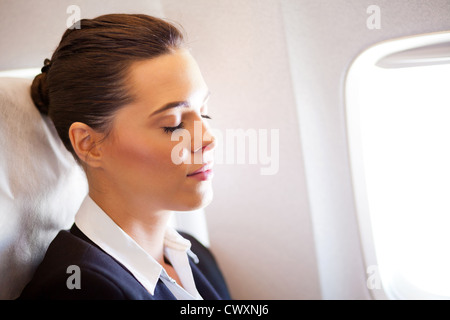 Belle jeune businesswoman resting on airplane Banque D'Images