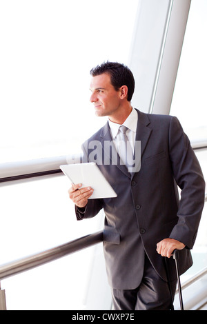 Businessman using tablet computer at airport Banque D'Images