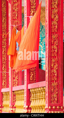 Robes de moines bouddhistes pendaison de sécher entre les colonnes d'un temple à Kampong Speu, Cambodge Banque D'Images