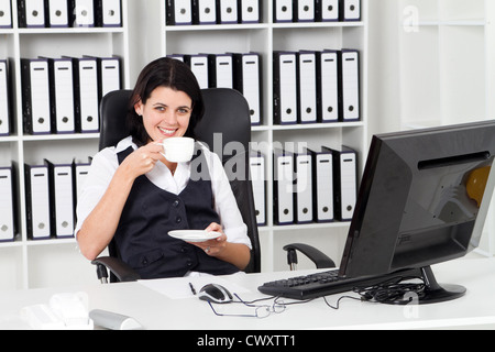 Young businesswoman drinking coffee in office Banque D'Images