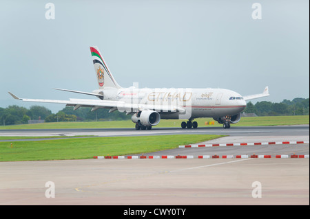 Un Airbus A330 d'Etihad le roulage sur la piste de l'Aéroport International de Manchester (usage éditorial uniquement) Banque D'Images