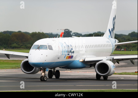 Un Flybe Embraer 190 roulant sur la piste de l'Aéroport International de Manchester (usage éditorial uniquement) Banque D'Images