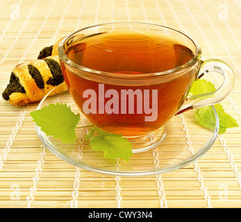 Plateau en verre tasse avec deux feuilles de menthe et les cookies sur une serviette en bambou Banque D'Images