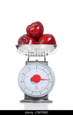 Pommes rouges sur une échelle de l'alimentation en acier inoxydable sur un fond blanc Banque D'Images