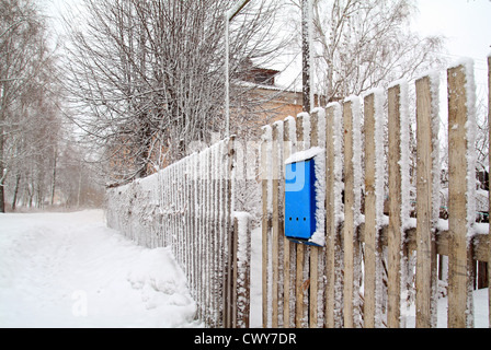 Boîte aux lettres bleu sur clôture en bois Banque D'Images