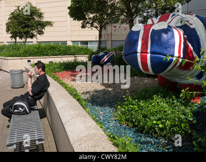 Un homme bénéficiant d'une cigarette dans du plastique d'hippopotames au centre commercial de Cribbs Causeway, peint par l'artiste Benjamin Jones. Banque D'Images