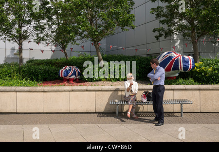 Un couple en face d'hippopotames en plastique au centre commercial de Cribbs Causeway, peint par l'artiste Benjamin Jones. Banque D'Images