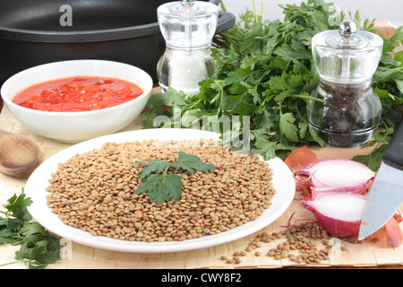 Ingrédients pour la soupe aux lentilles, y compris le persil, les lentilles, les oignons et les tomates. Banque D'Images