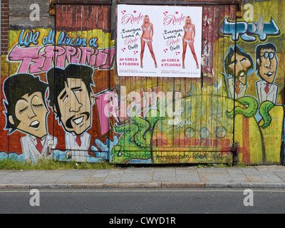 Graffiti des Beatles avec des affiches de strip club sur la porte à Liverpool Royaume-Uni Banque D'Images