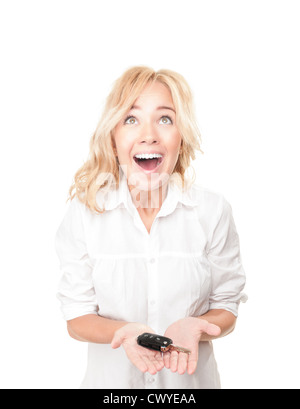 Portrait of pretty young girl holding a surpris car key dans ses mains isolé sur fond blanc. Expression de surprise, de choc Banque D'Images