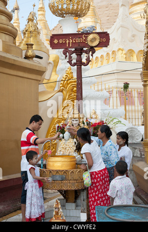 Fidèles à un lieu de culte à la base de Shwedagon Paya Shwedagon (), Yangon (Rangoon), le Myanmar (Birmanie) Banque D'Images