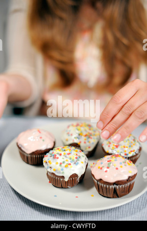 Femme avec des muffins sur la plaque Banque D'Images