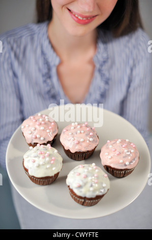 Femme tenant la plaque avec cinq muffins Banque D'Images