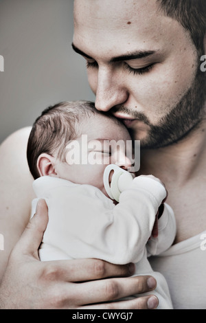 Père embrassant bébé de deux semaines Banque D'Images