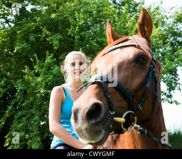 Smiling teenage girl riding horse Banque D'Images