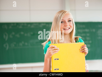 Smiling teenage girl holding en classe dossier de fichiers, portrait Banque D'Images