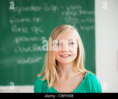 Smiling teenage girl in classroom, portrait Banque D'Images