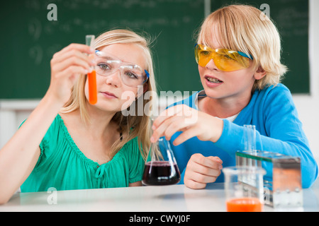 Lycéenne et écolier en expérimentant la classe chimique Banque D'Images