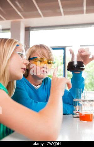 Lycéenne et écolier en expérimentant la classe chimique Banque D'Images