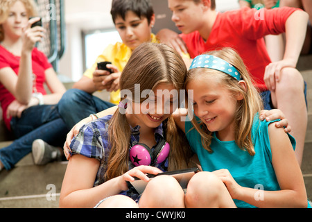 Deux smiling girls using tablet pc Banque D'Images