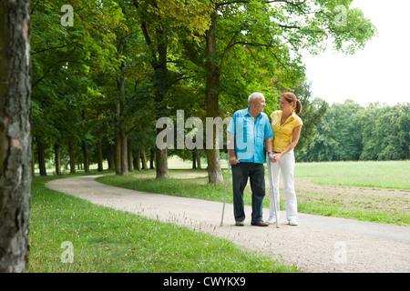 Woman walking with old man in park Banque D'Images