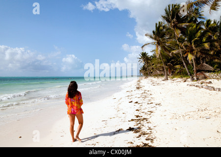 Jeune femme marchant sur la plage de Bwejuu, Zanzibar Afrique Banque D'Images