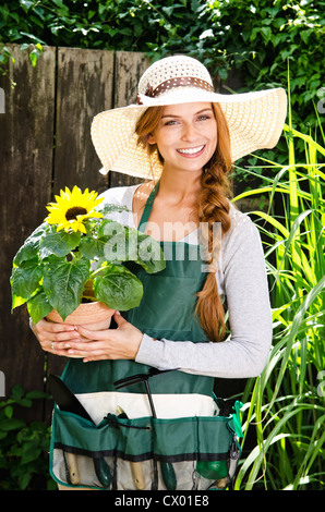 Souriante jeune femme avec le tournesol au jardin Banque D'Images