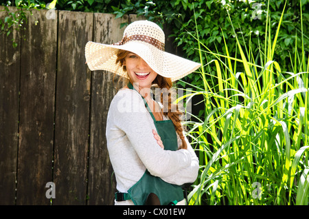 Happy young woman wearing sunhat et un tablier de jardin Banque D'Images