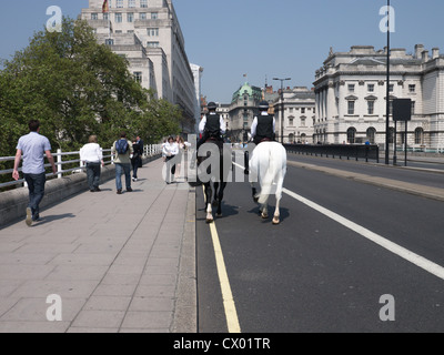 Les femmes deux cavaliers de la police en patrouille crossing Waterloo Bridge vers le Strand, London England Banque D'Images